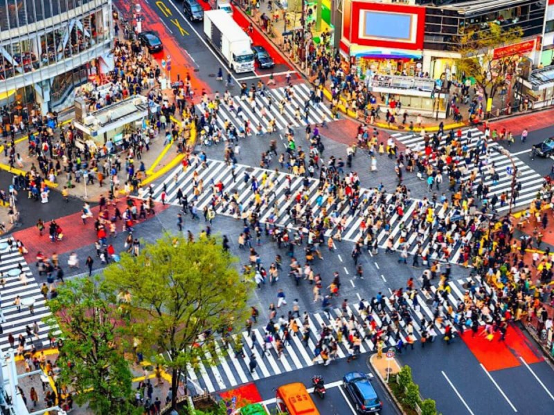 Lidé procházející křižovatkou Shibuya.